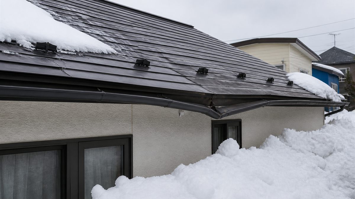 雪が滑り落ちた屋根と、押された軒樋