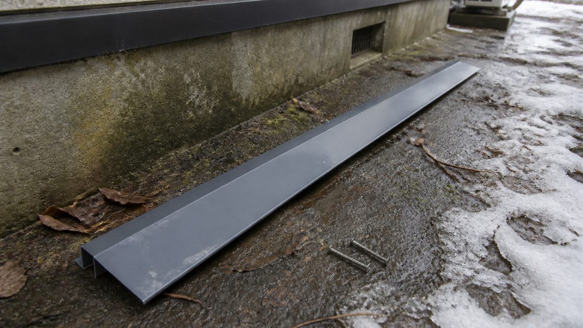 軒下の地面に落ちた細長い金属板と釘