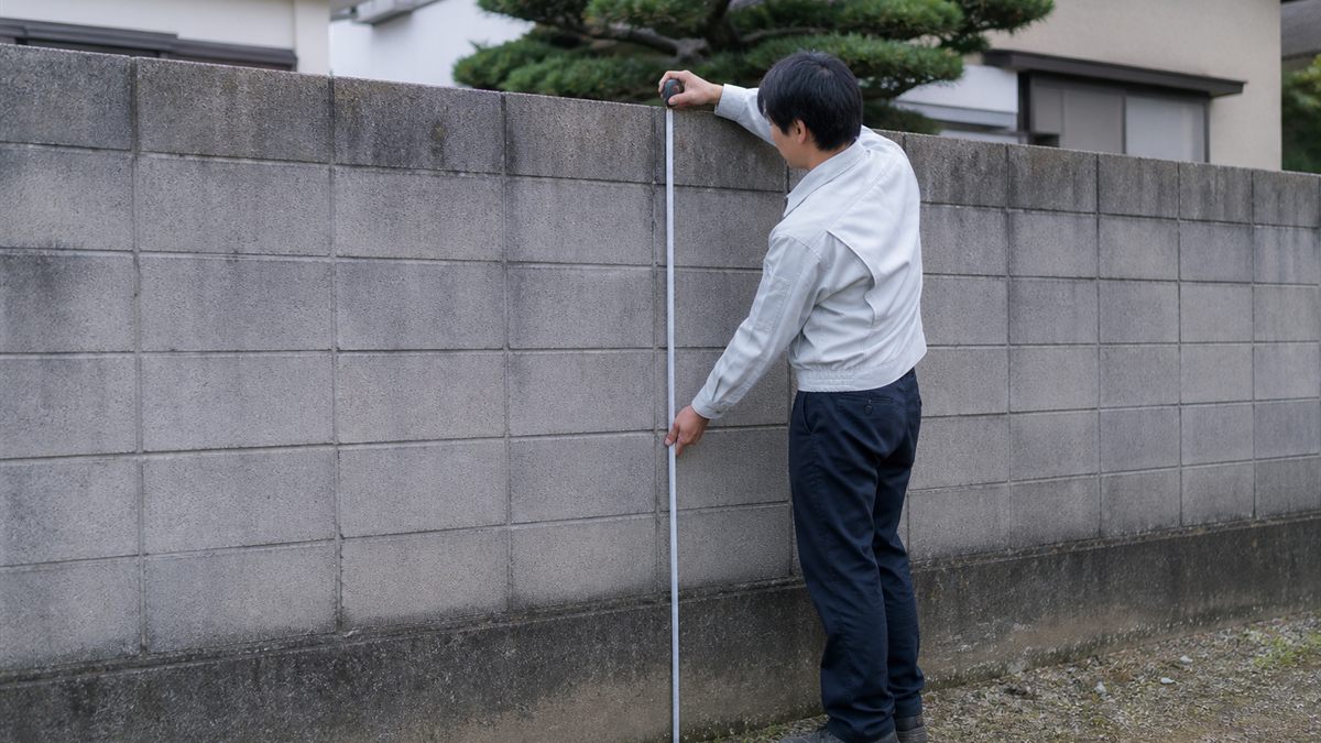 メジャーで塀の高さを測る