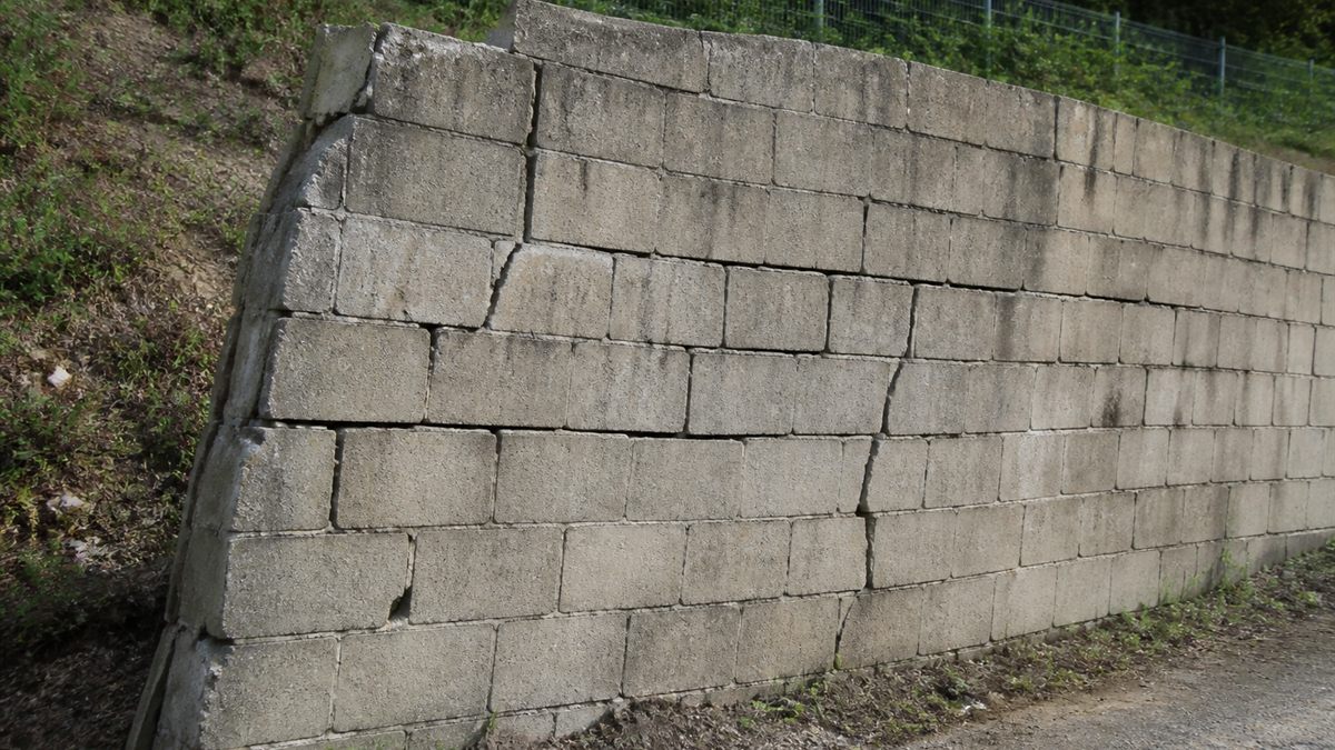 傾いた古いブロック塀