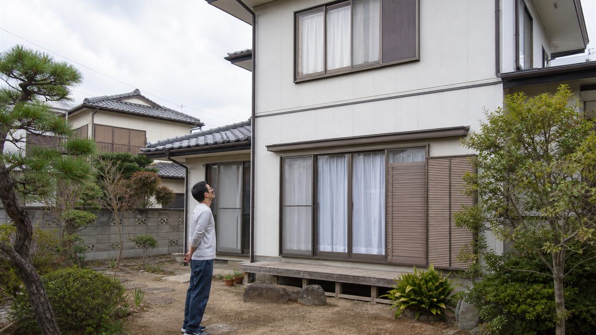外壁を見上げる人