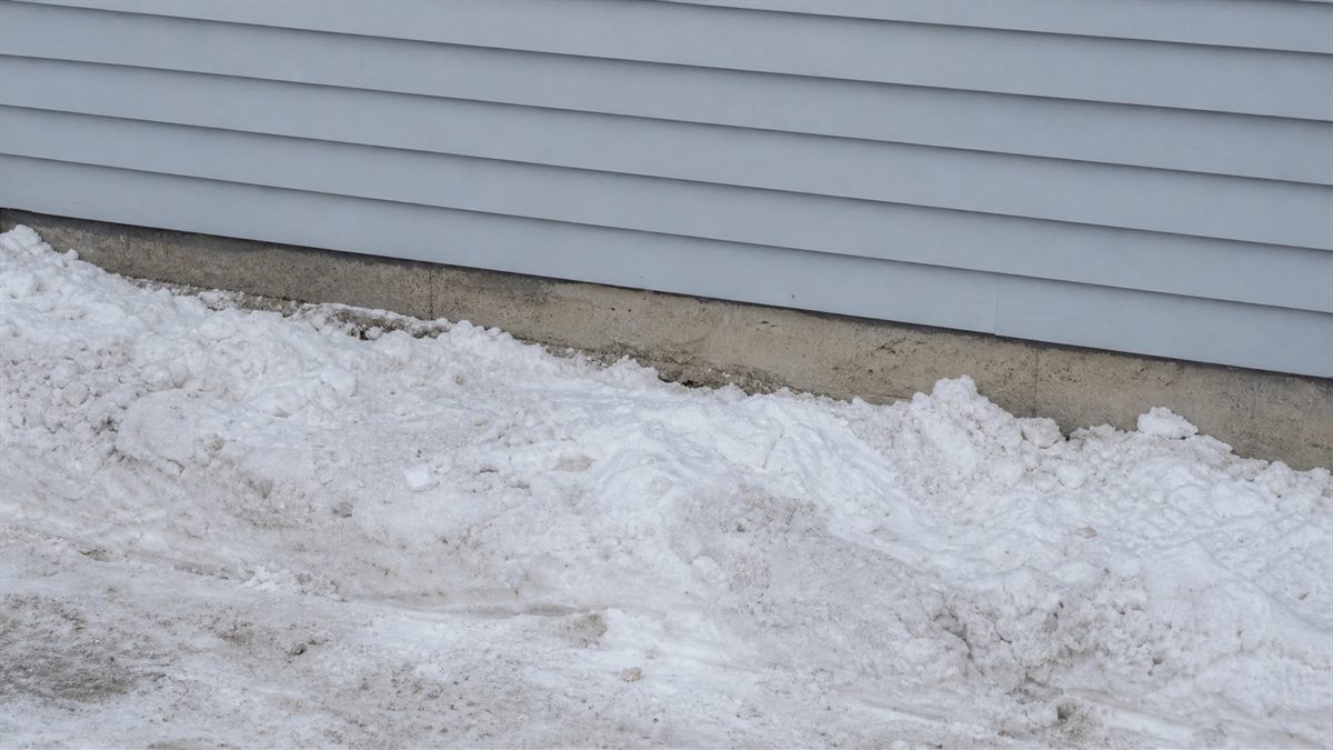 雪が寄せられた住宅の外壁の下部