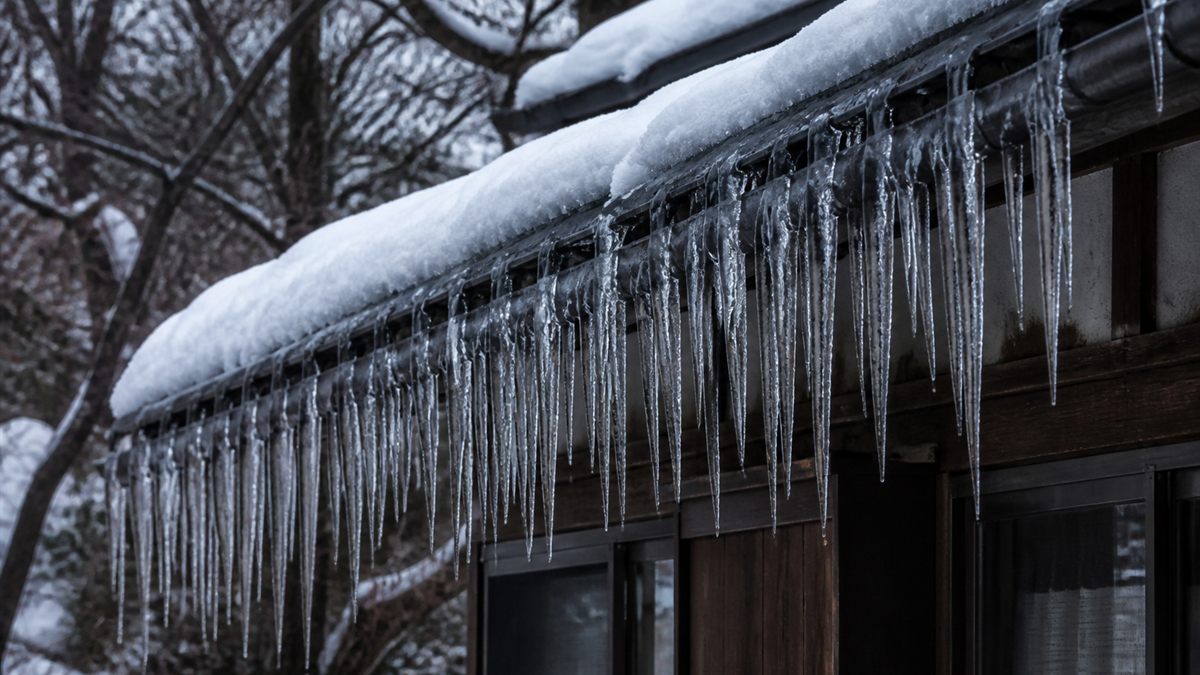 冬の屋根の軒先に下がるつらら