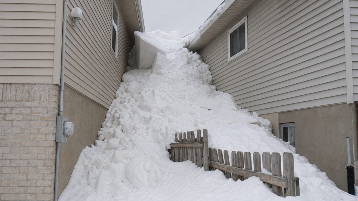住宅の間の狭い通路に落ちた大量の雪