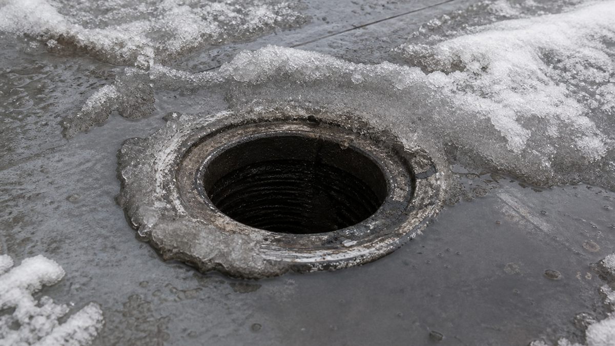 雪解け水があふれた屋根の排水口