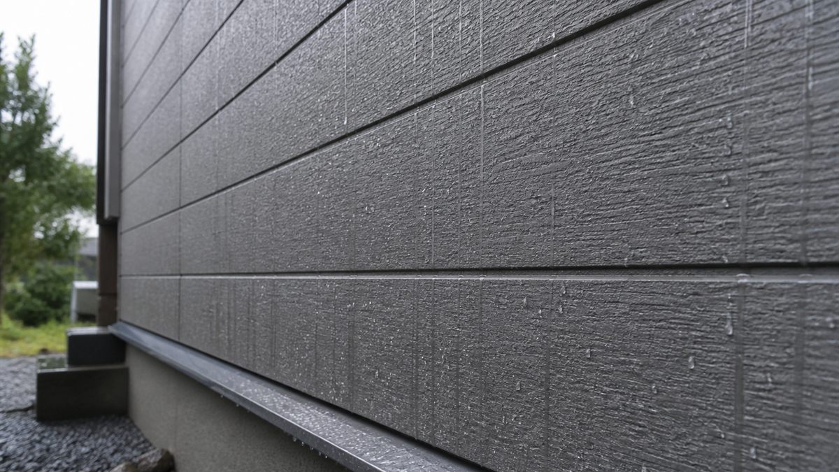 雨がつたう窯業系サイディングの壁面