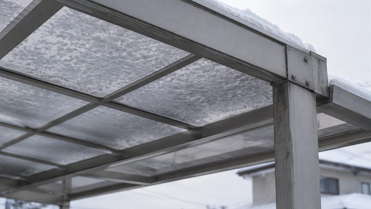 アルミの柱と梁に支えられた、新雪が載ったカーポートの屋根