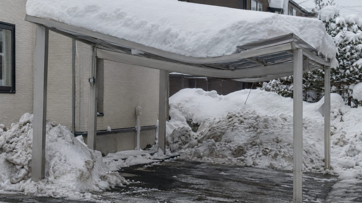 重い雪で屋根が中央からたわんだカーポート
